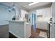 Open kitchen featuring white cabinets, breakfast bar, stainless steel refrigerator, and tile backsplash at 123 Wildwood Dr, Temple, GA 30179