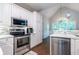 Bright kitchen featuring white cabinets, stainless steel appliances, and mosaic backsplash at 123 Wildwood Dr, Temple, GA 30179