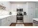 Well-lit kitchen with white cabinetry, stainless steel appliances, and hardwood flooring at 123 Wildwood Dr, Temple, GA 30179