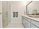 Bathroom showcasing a glass shower, neutral tiles, and gray cabinets at 125 Sidney St, Marietta, GA 30060