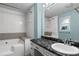 A bathroom featuring a shower, bathtub, black marble countertop with a white sink and a mirror at 175 Springvalley Way, Stockbridge, GA 30281
