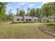 Charming yellow home with a well-kept lawn and ample space surrounded by lush trees at 175 Springvalley Way, Stockbridge, GA 30281