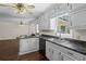 Kitchen area with dark countertops, white cabinets, and stainless steel dishwasher at 175 Springvalley Way, Stockbridge, GA 30281
