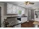 Kitchen with white cabinets, dark countertops, bar seating, and stainless steel dishwasher at 175 Springvalley Way, Stockbridge, GA 30281
