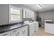 Laundry room featuring a sink, countertop, window, and multiple machines for laundry at 175 Springvalley Way, Stockbridge, GA 30281
