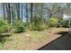 View of back yard showing mature trees and landscaping plus back of home and partial deck structure at 4590 Cedar Ridge Trl, Stone Mountain, GA 30083