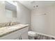 This bathroom offers a sink with a granite countertop, a toilet, and a mirror in a setting with neutral colored walls at 4590 Cedar Ridge Trl, Stone Mountain, GA 30083