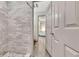 Modern bathroom with neutral stone tile shower and view to bedroom at 5 Northlake Cir # 4 & 5, Peachtree City, GA 30269
