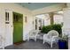 Inviting front porch featuring white wicker chairs and a charming green front door at 3120 Church St, Atlanta, GA 30344
