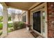 Inviting front porch with brick flooring, a welcoming black door, and decorative potted flowers at 510 Towneside Ln, Marietta, GA 30064