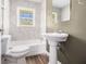 Bathroom with a pedestal sink, bathtub and shower combination with stylish marble-look wall tile at 1958 Long Dr, Decatur, GA 30032