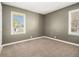 A bright bedroom with new carpeting, two windows, and freshly painted walls at 1958 Long Dr, Decatur, GA 30032