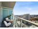 Relax on this cozy balcony featuring seating, a table, plants, and a stunning city view at 3325 Piedmont Ne Rd # 2104, Atlanta, GA 30305