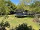 Large backyard featuring a trampoline, lush lawn, and mature trees, ideal for recreation and outdoor activities at 5167 Manitu Sw Ct, Lilburn, GA 30047
