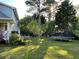 Spacious backyard with a trampoline, lush green lawn, mature trees, and a glimpse of the home's exterior at 5167 Manitu Sw Ct, Lilburn, GA 30047