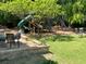 Spacious backyard with a playset, mature trees, and comfortable seating area perfect for outdoor relaxation and entertainment at 5167 Manitu Sw Ct, Lilburn, GA 30047