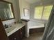 Bathroom featuring a jacuzzi tub, a shower with a shower curtain and a sink at 5167 Manitu Sw Ct, Lilburn, GA 30047