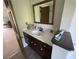 View of bathroom vanity with tile counters and a mirror reflecting the shower at 5167 Manitu Sw Ct, Lilburn, GA 30047