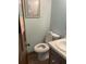 Powder room with white toilet, sink, and tiled floor, complemented by light blue walls and rustic decor at 5167 Manitu Sw Ct, Lilburn, GA 30047