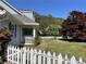 Inviting home with a beautiful lawn, mature trees, and white picket fence at 5167 Manitu Sw Ct, Lilburn, GA 30047