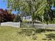 Beautiful tree in the front of a home with white picket fence and manicured lawn at 5167 Manitu Sw Ct, Lilburn, GA 30047