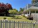 Charming home showcasing a beautiful lawn, white picket fence, and mature trees enhancing curb appeal and creating privacy at 5167 Manitu Sw Ct, Lilburn, GA 30047