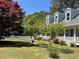 Landscaped front yard with a white picket fence, flowering trees, and lush green grass creates a picturesque setting at 5167 Manitu Sw Ct, Lilburn, GA 30047