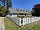 Charming home featuring a white picket fence, manicured lawn, and covered porch at 5167 Manitu Sw Ct, Lilburn, GA 30047