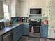 Well-lit kitchen with stainless steel appliances, granite countertops, and painted cabinets at 5167 Manitu Sw Ct, Lilburn, GA 30047