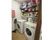 Practical laundry area with modern machines and convenient shelving for storage solutions at 5167 Manitu Sw Ct, Lilburn, GA 30047