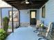 Inviting covered porch with seating area, decorative lighting, and views of the manicured garden at 727 Channing Nw Dr, Atlanta, GA 30318
