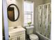 Bathroom featuring a white vanity, oval mirror, and tub with a leaf-patterned shower curtain at 1715 Crestwell Ln, Grayson, GA 30017