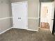 Bedroom with neutral carpet, white trim, and double door closet at 1715 Crestwell Ln, Grayson, GA 30017