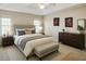 Stylish bedroom featuring a large bed, bench, matching nightstands, and a large dresser with elegant decor at 1715 Crestwell Ln, Grayson, GA 30017