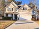 Traditional home boasts neutral siding, black shutters, two car garage, brick accents and mature landscaping at 1715 Crestwell Ln, Grayson, GA 30017