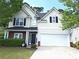 Charming two-story home features vinyl siding, black shutters, manicured lawn and attached two-car garage at 1715 Crestwell Ln, Grayson, GA 30017