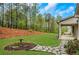 Manicured lawn with stone walkway to covered back porch and landscaped hillside at 174 Vandiver Ct, Acworth, GA 30101
