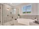 Bathroom features a large soaking tub, tiled shower, and gray tiled walls at 174 Vandiver Ct, Acworth, GA 30101