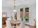 Dining room boasts a round wooden table and has French doors leading to a patio area with a view of the landscaped yard at 174 Vandiver Ct, Acworth, GA 30101