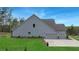 Side exterior of home with three car garage, well-manicured lawn and landscaping at 174 Vandiver Ct, Acworth, GA 30101