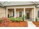 Inviting front porch with stone flooring, rocking chairs, and charming curb appeal at 174 Vandiver Ct, Acworth, GA 30101