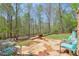 Landscaped backyard featuring a stone patio with seating, a fire pit and a lush green space at 205 Northampton Ct, Canton, GA 30115