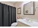 Neutral bathroom featuring a white vanity, framed mirror, and a shower with a black curtain at 205 Northampton Ct, Canton, GA 30115