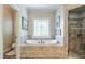 This primary bathroom features a soaking tub with decorative glass window and a tiled shower at 205 Northampton Ct, Canton, GA 30115
