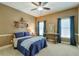 Bedroom with a ceiling fan, two windows with blue curtains, and neutral paint at 205 Northampton Ct, Canton, GA 30115