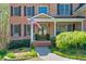 Inviting front entrance with brick steps, an American flag, and lush landscaping leading to a covered porch at 205 Northampton Ct, Canton, GA 30115