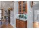 Elegant bar area with wooden cabinets, a mirrored backsplash, and decorative glass storage at 1207 Promontory Path, Marietta, GA 30062