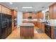 Spacious kitchen features wooden cabinets, a central island, hardwood floors and black appliances at 1207 Promontory Path, Marietta, GA 30062