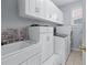 Clean laundry room featuring white cabinets, a utility sink, washer, and dryer at 1207 Promontory Path, Marietta, GA 30062