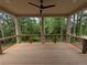Spacious covered back porch featuring a ceiling fan and peaceful views of the surrounding woods at 380 Hillcrest View Dr, Suwanee, GA 30024